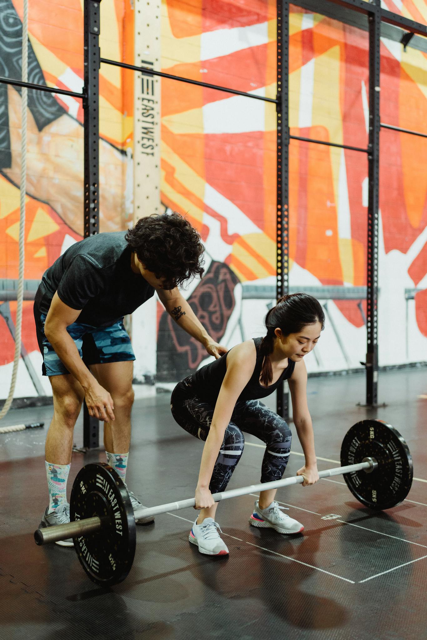 Crafting the Perfect Blog Structure: A Guide for Effective Blogging A female weightlifter getting coached on lifting techniques in an indoor gym.