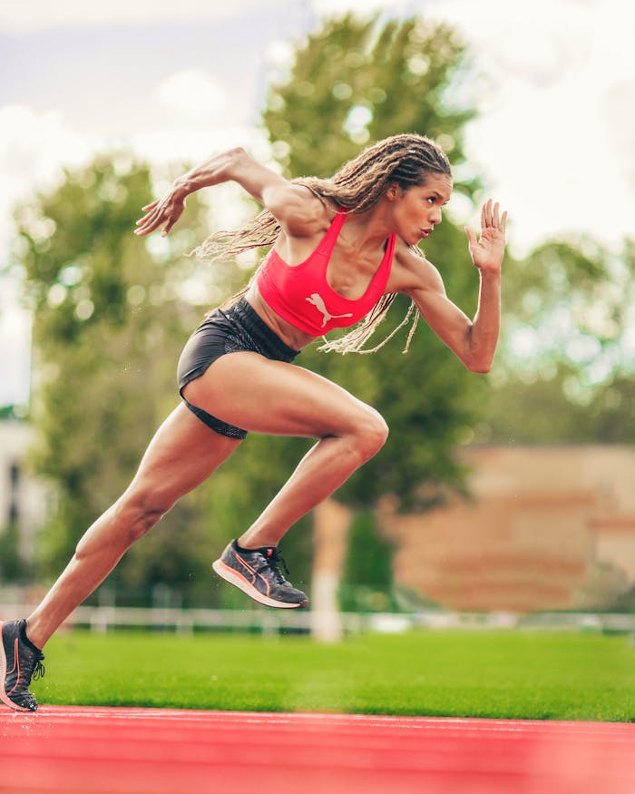 Mastering the First Impression: Your intriguing post title goes here Female athlete in sportswear sprinting on a track, showcasing power and speed. Outdoor action shot.